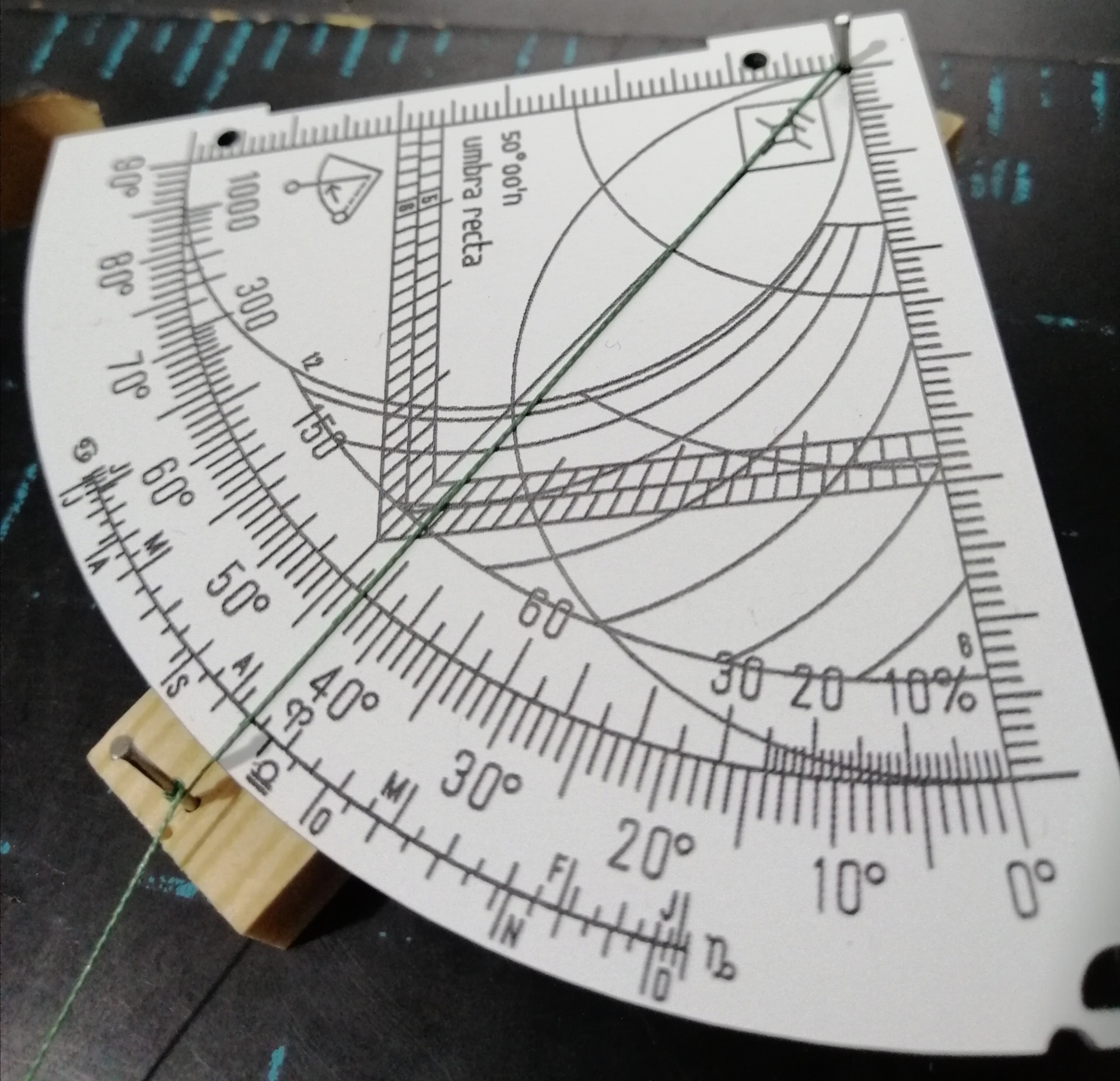 Figure 4: To make sighting easier, a small wooden bar with two small nails can be used. One nail is positioned at the vertex of the quadrant and another one outside of the quadrant. The string aligned between the vertex and the outer nail helps to set the azimuth you are looking for.